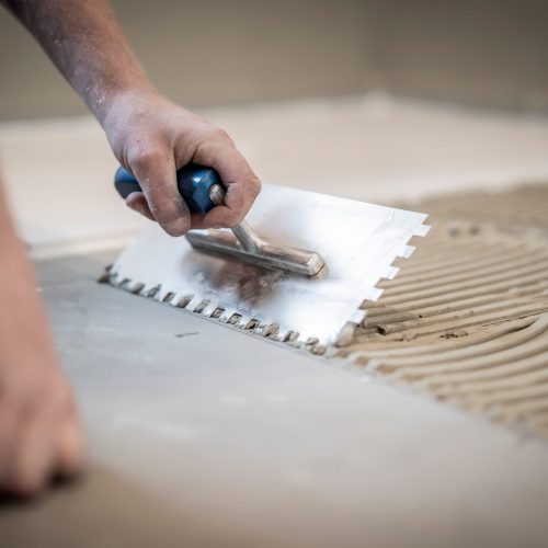 Fliesenleger bei der Arbeit, Renovierung eines Badezimmers Fliesenleger bei der Arbeit, Renovierung eines Badezimmers